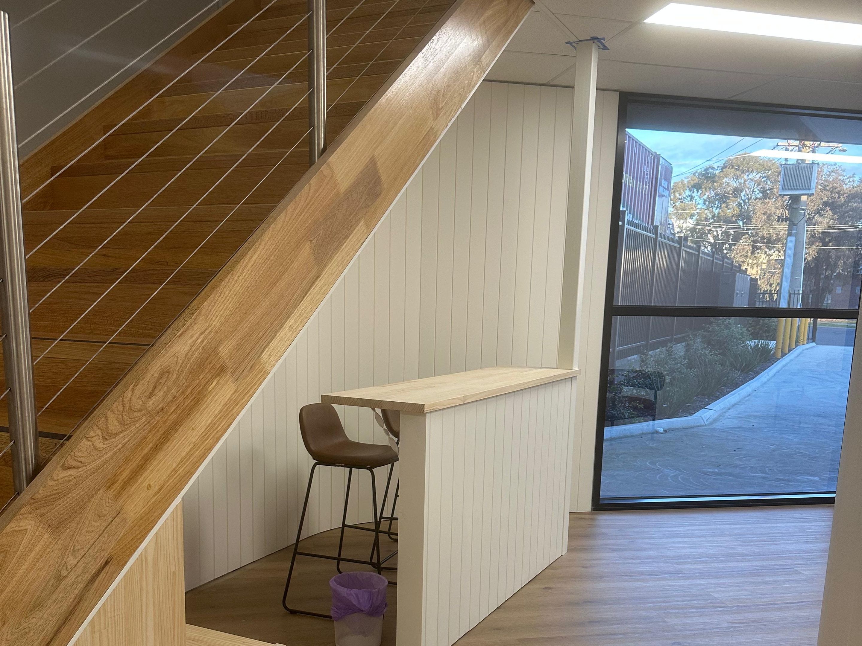 Timber stair with a cable balustrade beside a breakout bar