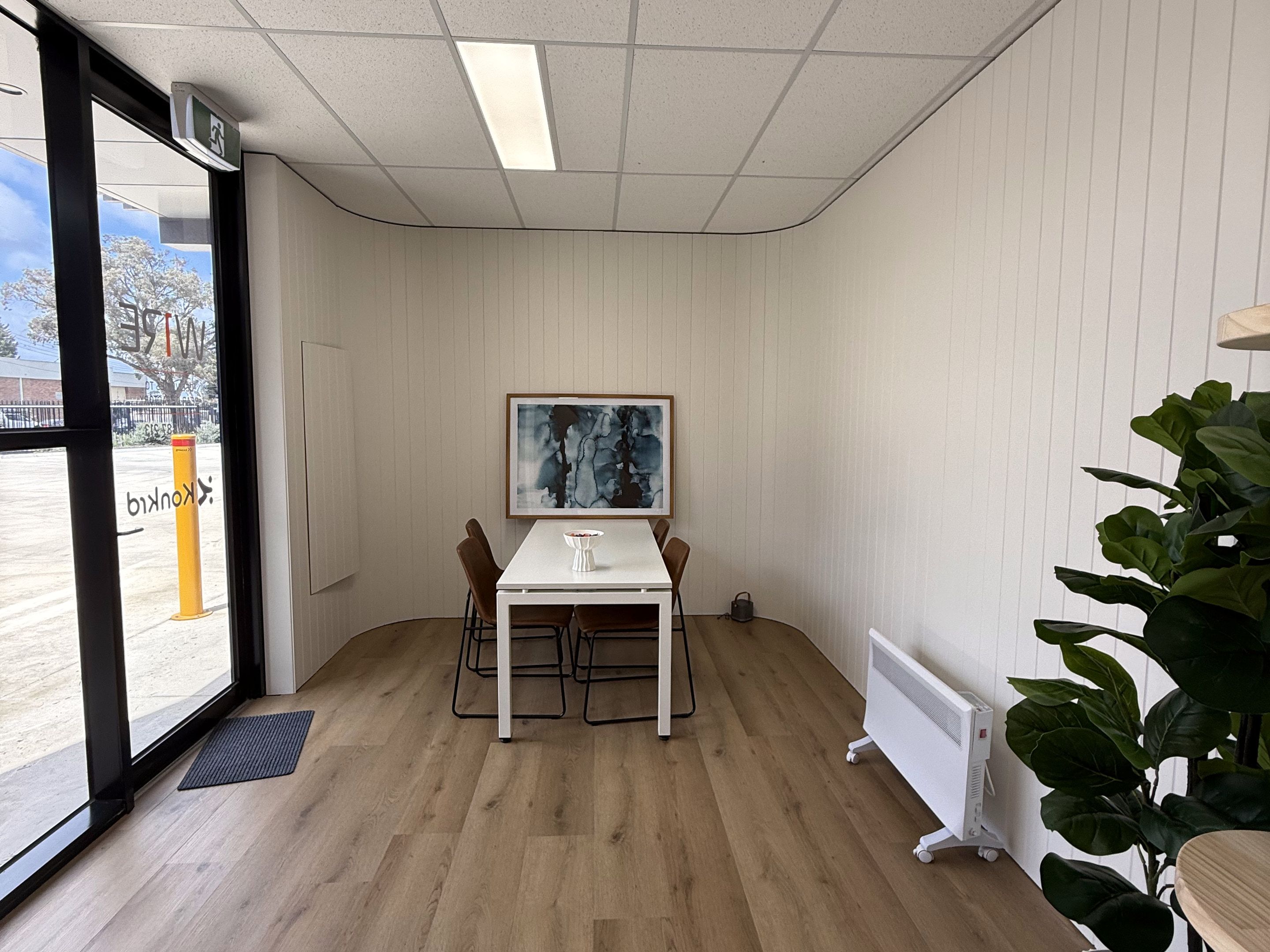 Meeting room table and chairs beside a large window