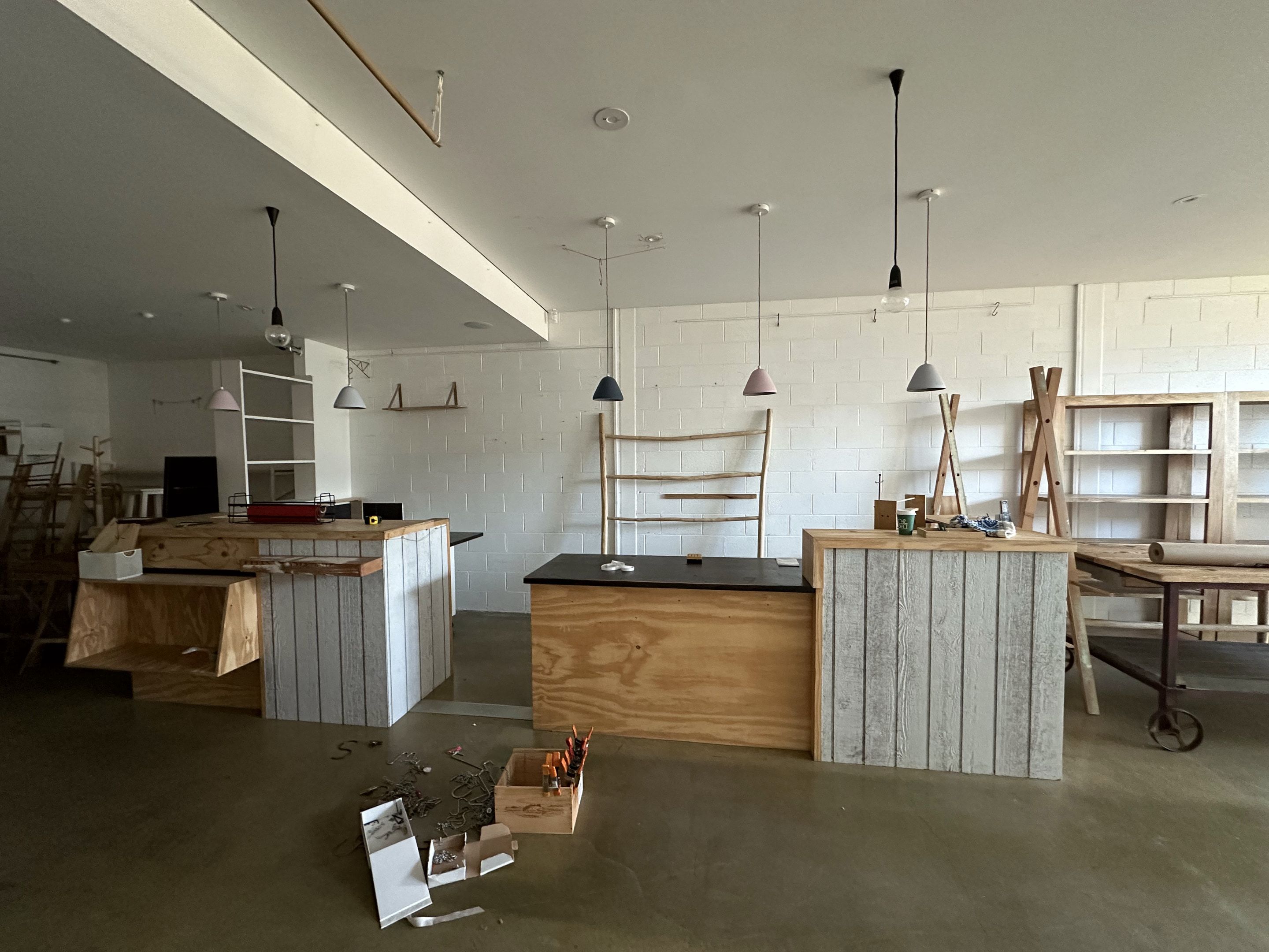 Plywood shop counters under pendant lights during fitout