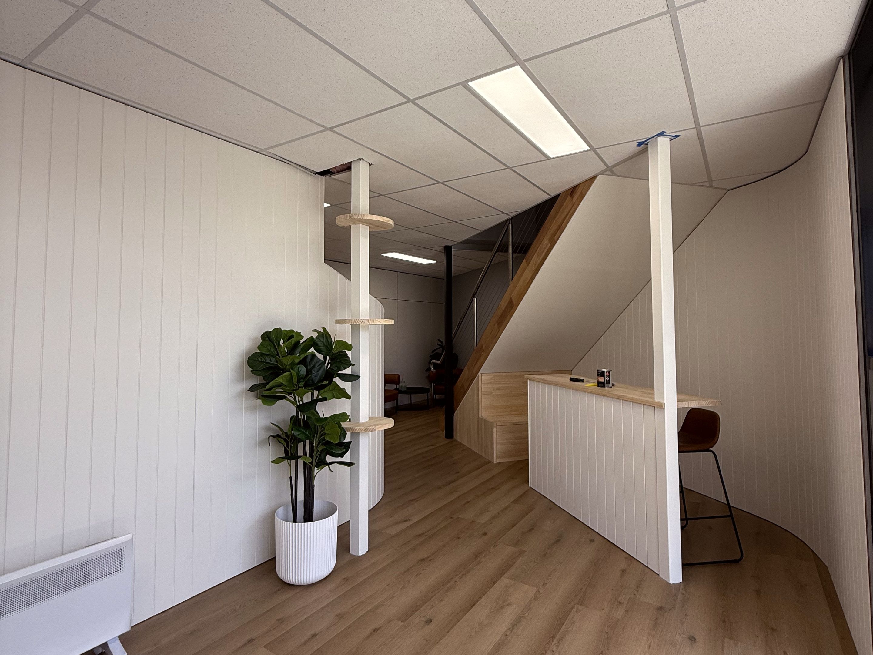 Curved corridor wall beside a spiral stair and breakout bar