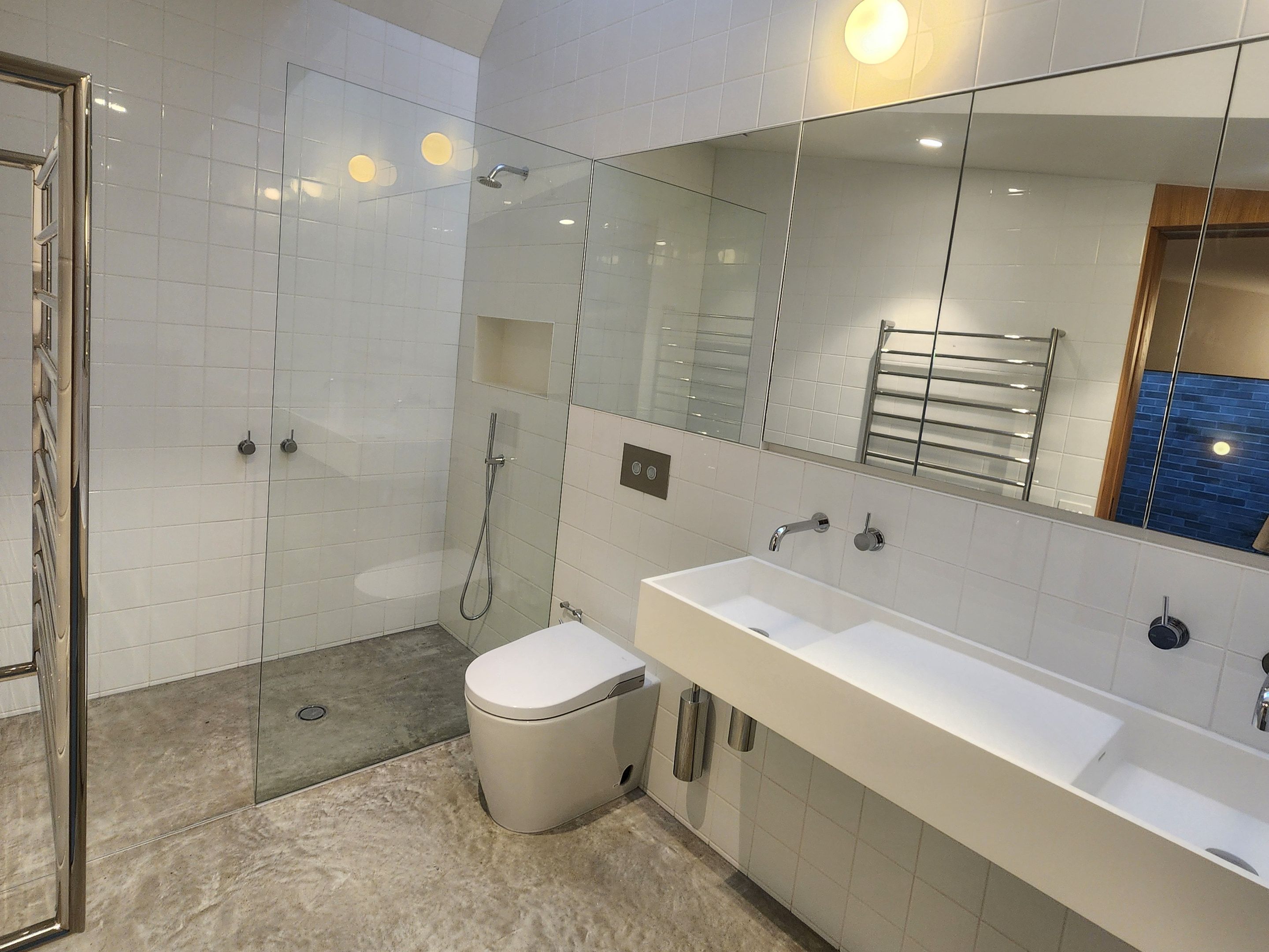 Bathroom with a glass shower screen, wall-hung vanity and mirrored cabinet