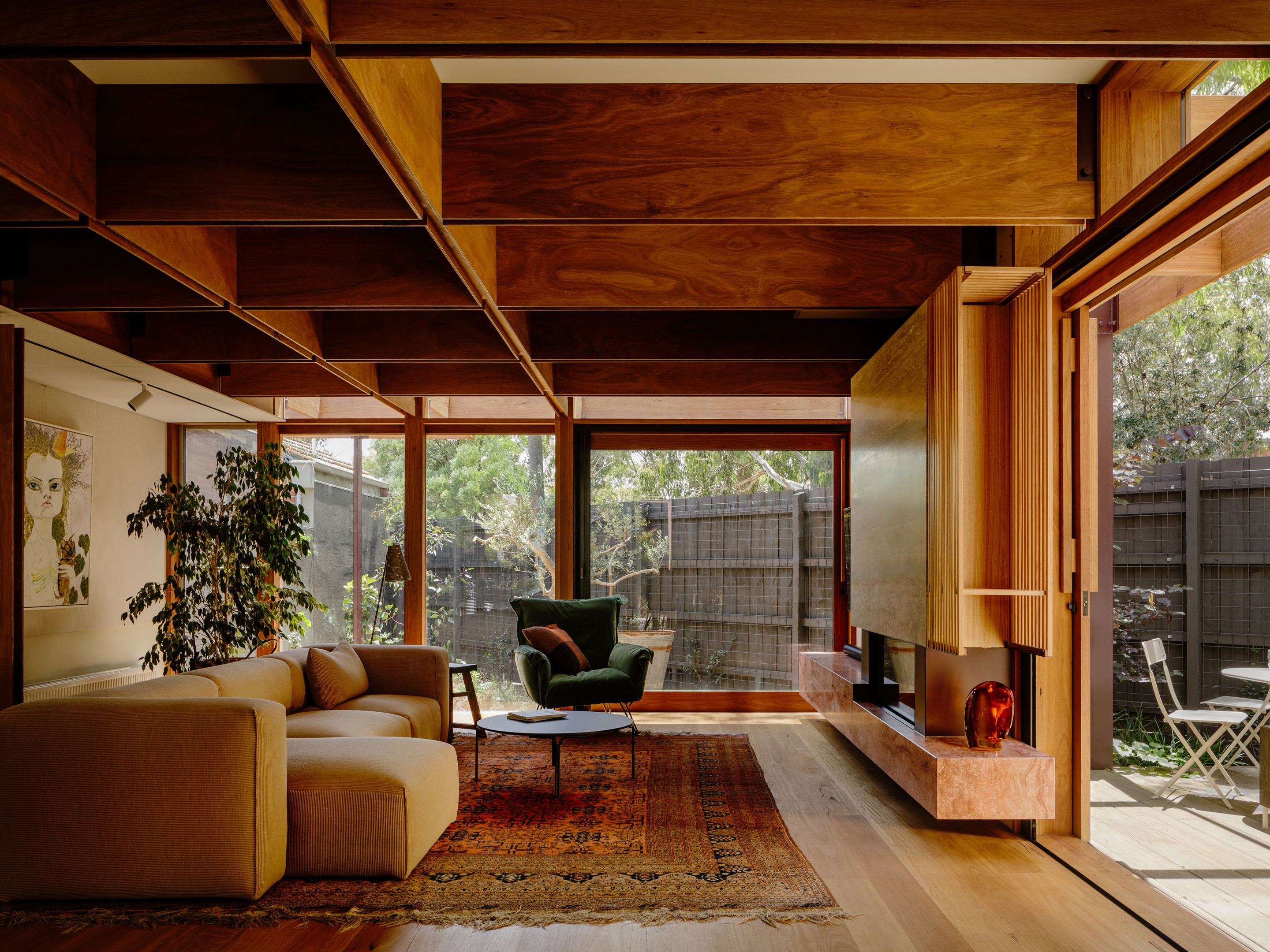 Living room with exposed timber beams opening to a courtyard garden